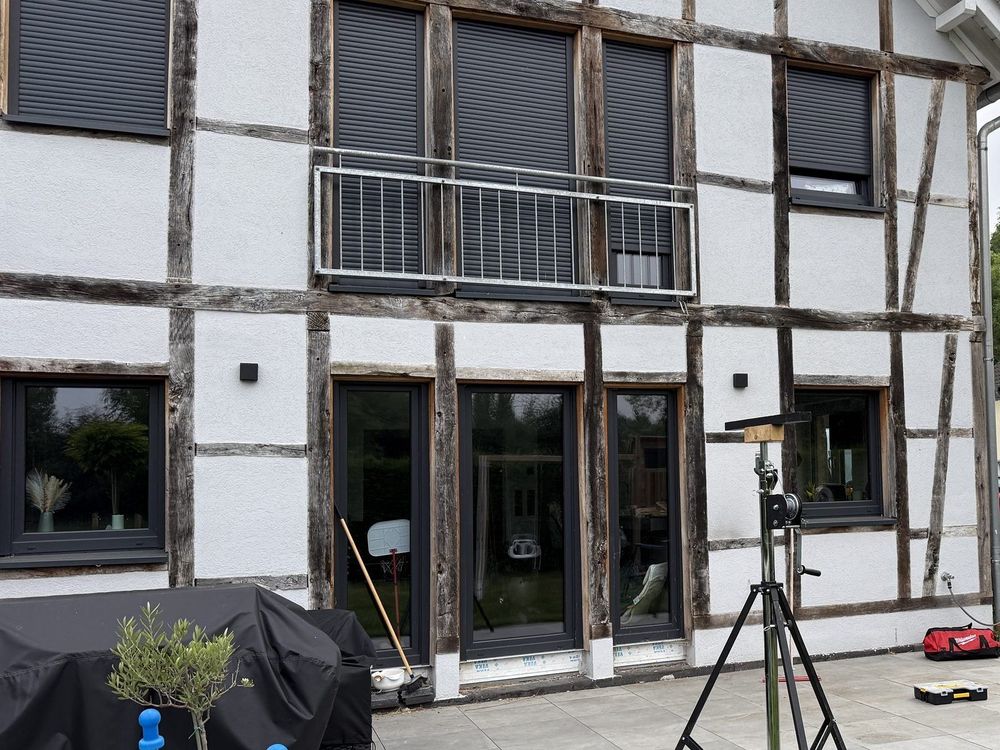 Terrasse an einem Fachwerkhaus vor dem Aufbau einer Terrassenüberdachung, Montagestützen stehen bereit