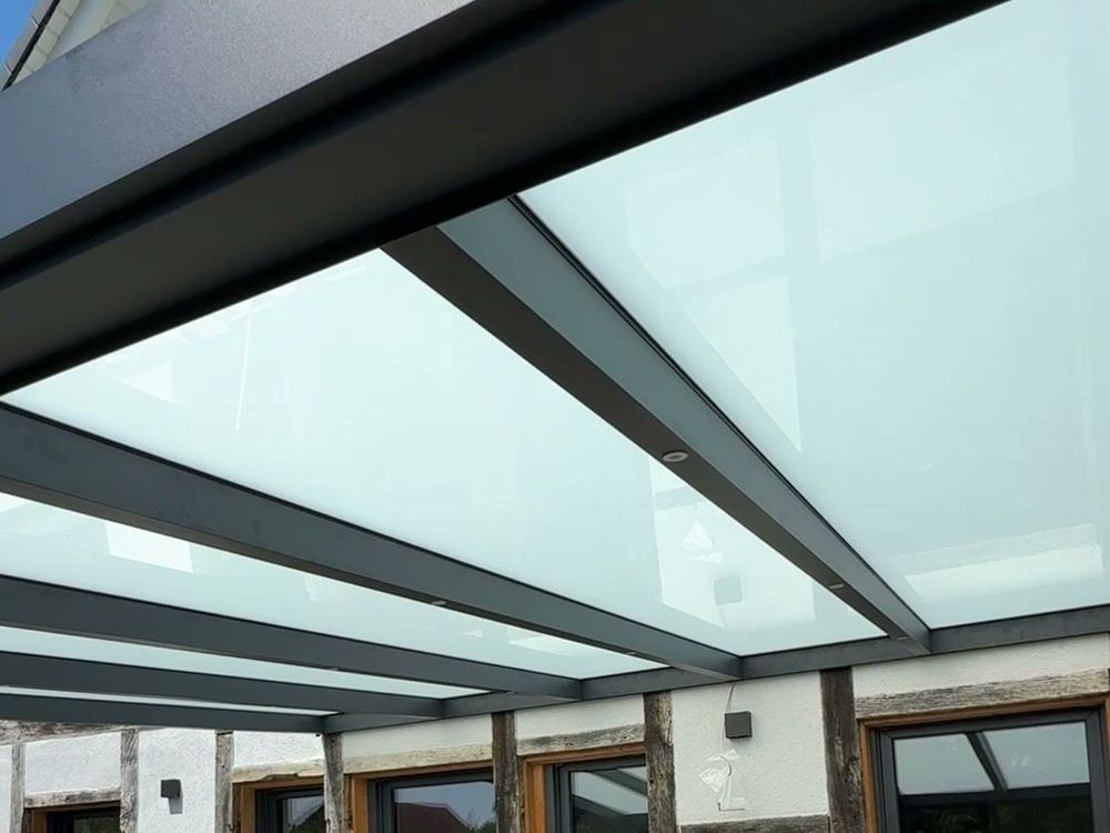Blick unter ein Terrassendach mit satiniertem VSG-Glas und anthrazitfarbenen Sparren