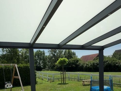 Überdachte Terrasse mit Glasdach und Blick in den Garten